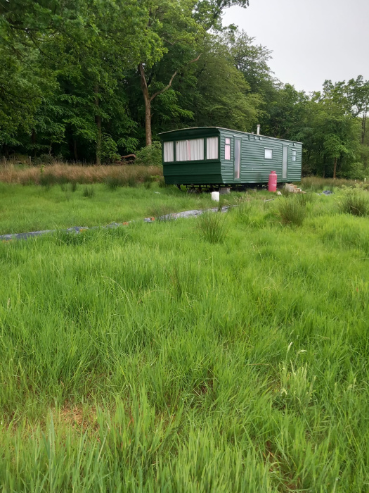 Static caravan with forest green paint - included with sale.